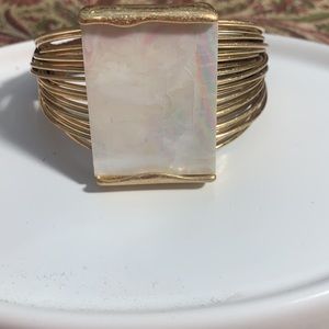 Gold cuff bracelet with mother of pearl center designed by Robert Lee Morris